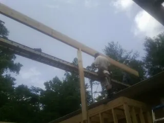 Carpenter setting a ridge beam over a new addition frame — Ice Dam Removal by Roofing Brothers in Westport Point