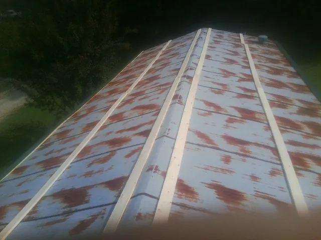 Rusted metal roof panels with new wood purlins before replacement — Storm Damage Roof Repair in Westport Point by Roofing Brothers