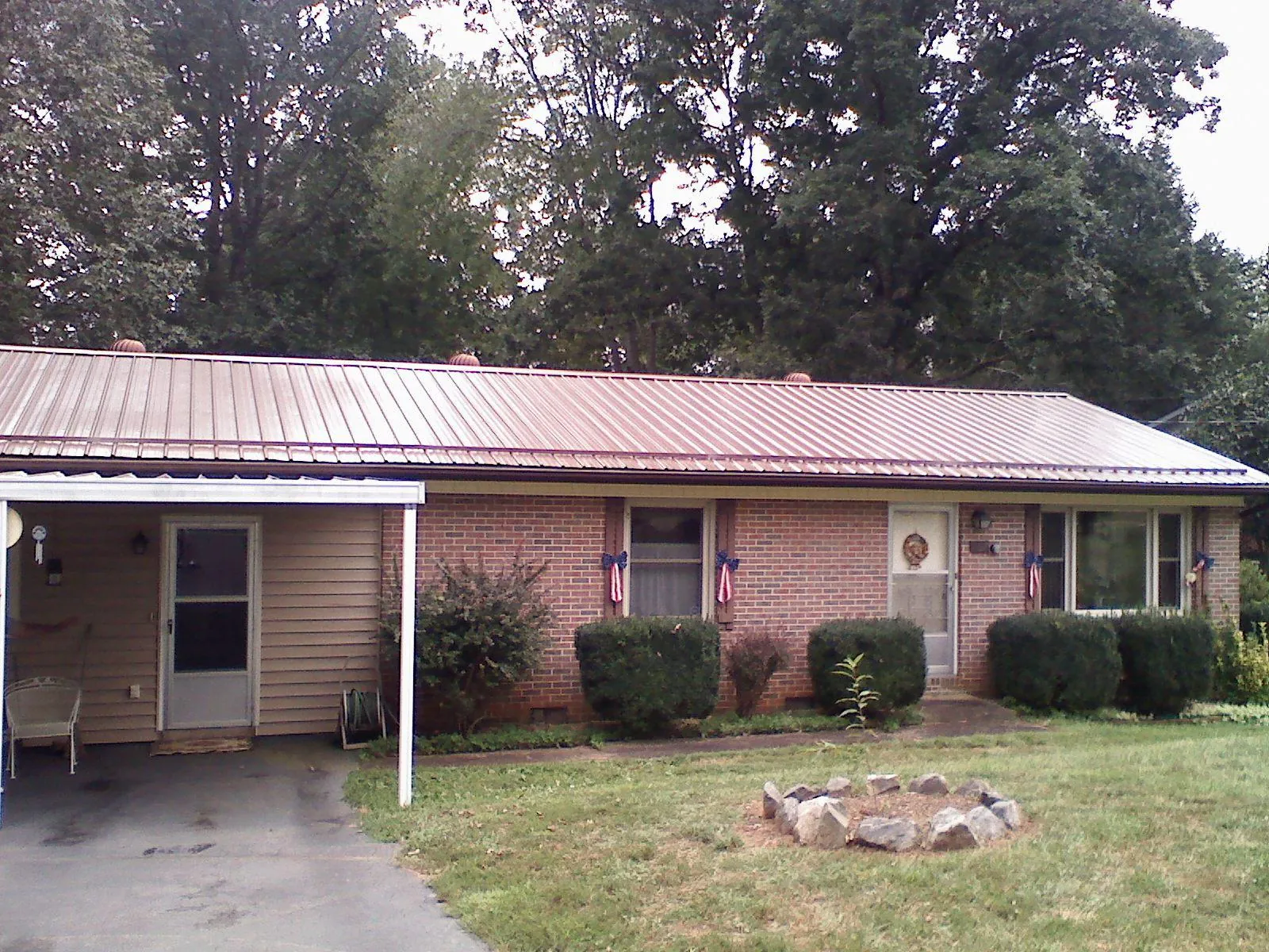 Bronze metal roof and carport on a brick ranch home — Roof Repair work by our crew in Westport Point